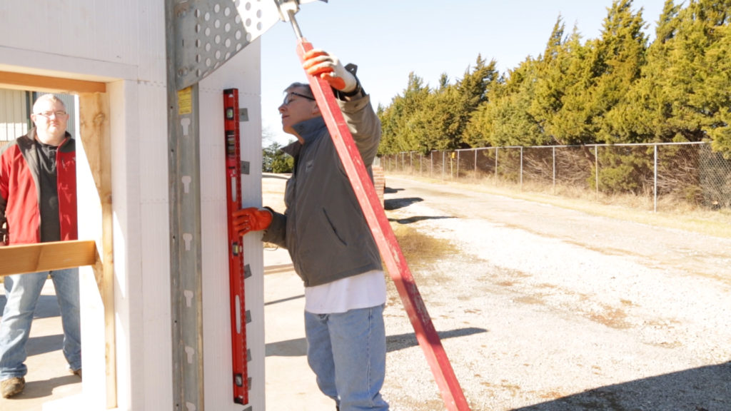 Team member adjusting the bracing to level the wall