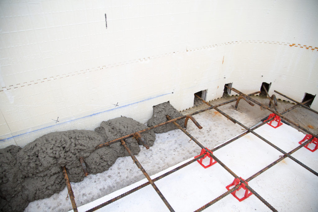Concrete pouring into ICF pools walls and floor.
