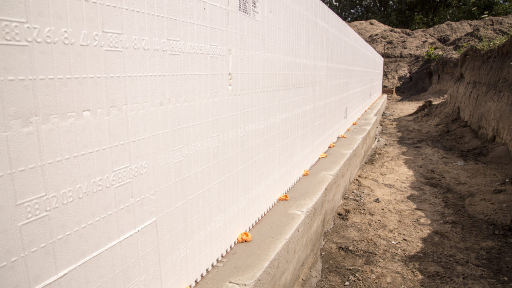 An ICF wall stacked along chalk lines on the footing and spot glued
