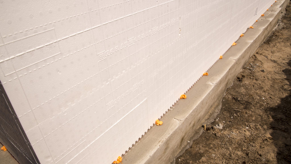 An ICF wall stacked along chalk lines on the footing and spot glued