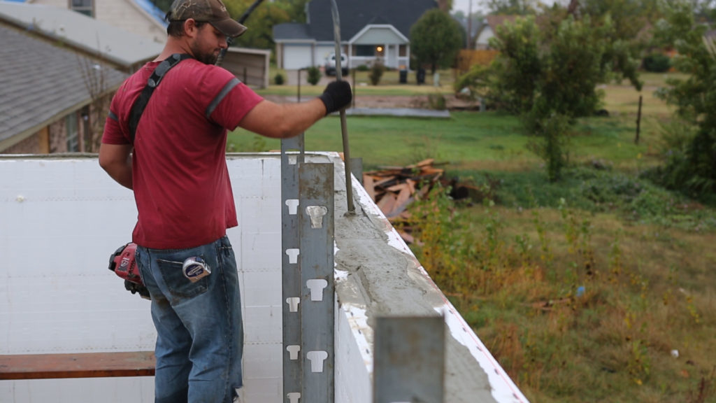Team member using a pencil vibrator to vibrate concrete